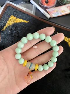 玉石手链 这是一条翡翠玉石手串 加了两片蜜蜡隔片 天然和田玉加南红